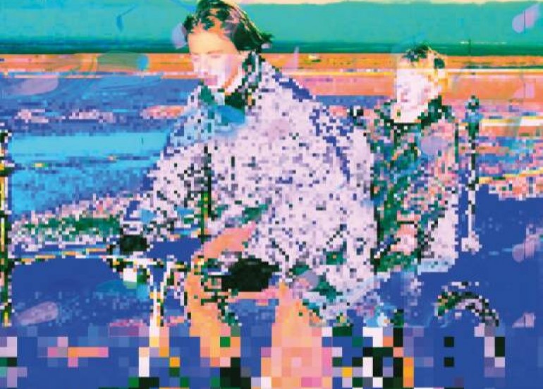 man watching a band on the stage wearing a red t-shirt and black hat.