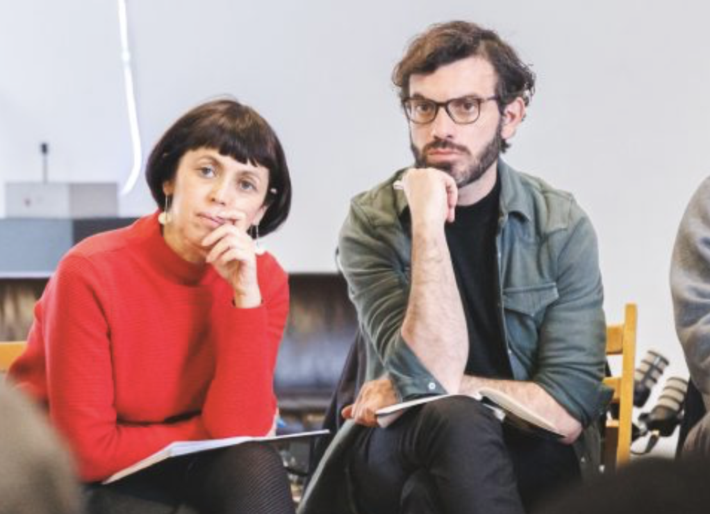 DJ facing a crowd at his deck. Photo with a purple hue
